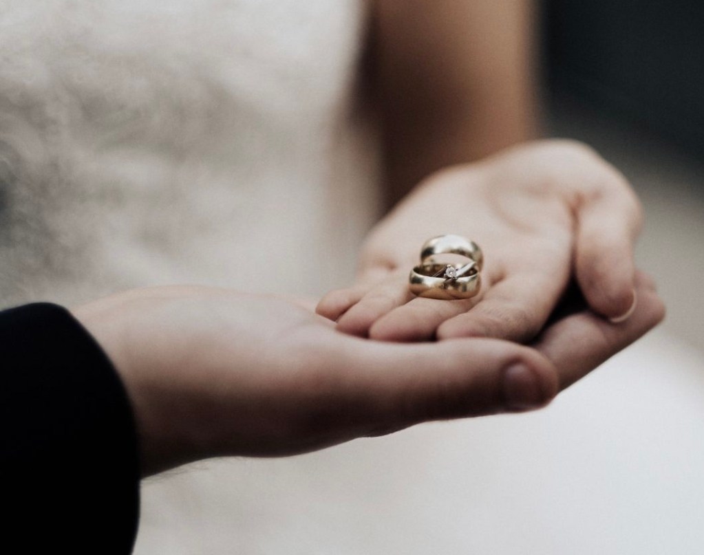 Hände eines Brautpaares mit Eheringen