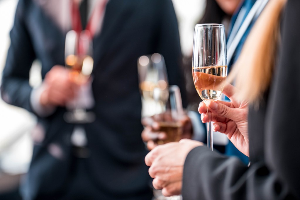 Männer im Anzug mit Champagnergläser in der Hand;